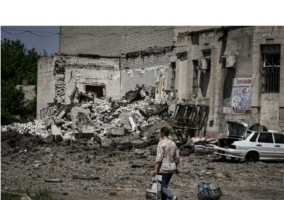 A woman walks in front of a building destroyed by a strike in the city of Lysytsansk at the eastern Ukrainian region of Donbas. Photograph: Aris Messinis/AFP via Getty Images